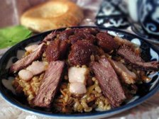 Плов из перловки с мясом в тарелке